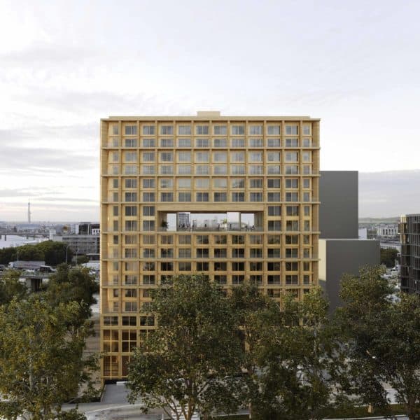 Wood Up tower in Paris's 13th arrondissement - a 50-meter sustainable luxury apartment building featuring wooden construction, private balconies, and modern architectural design against the Parisian skyline near the Duo towers